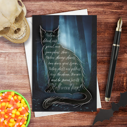 Lifestyle image of the Halloween black cat greeting card: "When black cats prowl, and pumpkins shine..."