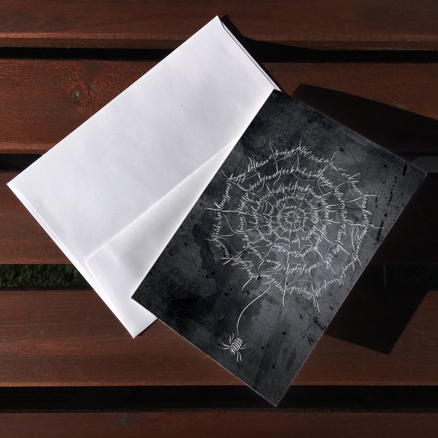 A top lifestyle view of the Halloween calligraphy card "Spider Web" design