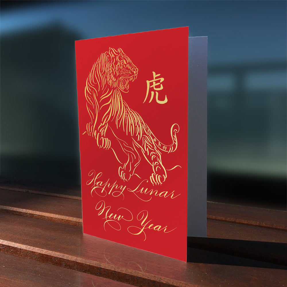 Lifestyle outdoor image of the calligraphy greeting card: Happy Lunar New Year of the Tiger in Gold foil design
